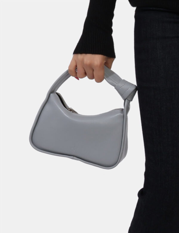 Borsa Calvin Klein Grigio - Borsa simil pochette di piccole dimensioni in total grigio chiaro. Presente unico scompartimento
