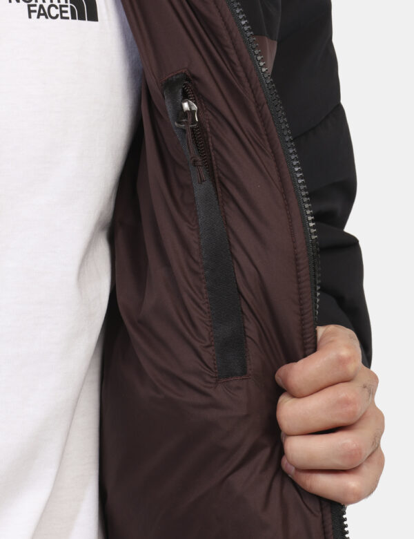 Piumino The North Face Marrone - Piumino bicolor marrone e nero. Presenti tasche a taglio trasversale con chiusura a zip. La