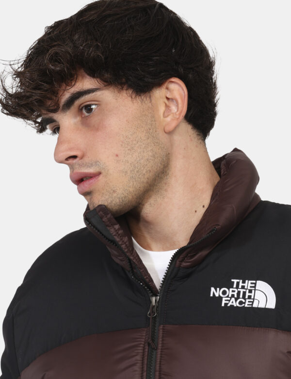 Piumino The North Face Marrone - Piumino bicolor marrone e nero. Presenti tasche a taglio trasversale con chiusura a zip. La