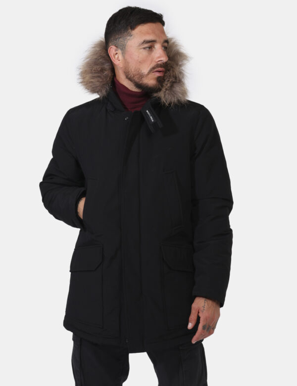 Giaccone Woolrich Nero - Giaccone in total nero con cappuccio arricchito da fake fur. Presenti tasche a taglio più tasche co