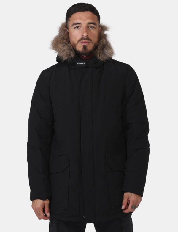 Giaccone Woolrich Nero - Giaccone in total nero con cappuccio arricchito da fake fur. Presenti tasche a taglio più tasche co