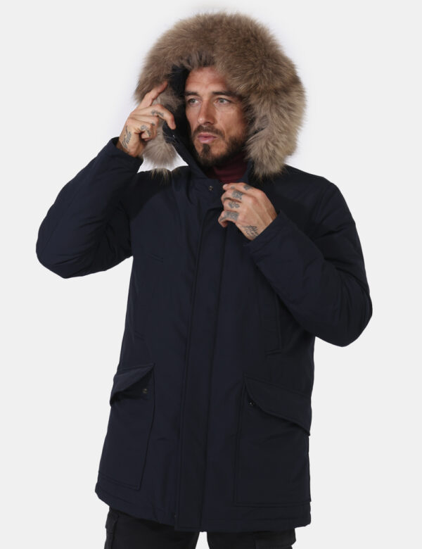 Giaccone Woolrich Blu - Giaccone in total blu navy con cappuccio arricchito da fake fur. Presenti tasche a taglio più tasche
