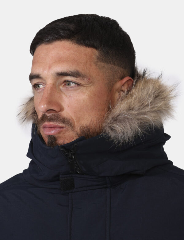 Giaccone Woolrich Blu - Giaccone in total blu navy con cappuccio arricchito da fake fur. Presenti tasche a taglio con chiusu