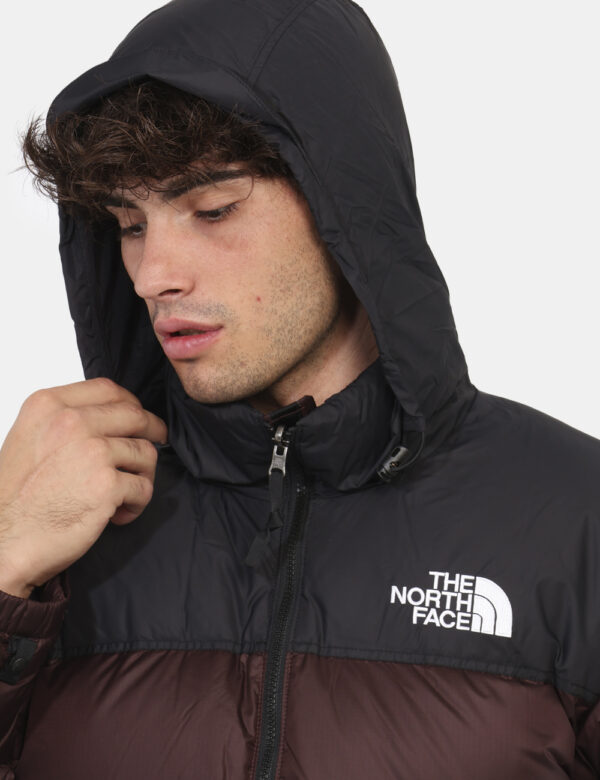 Piumino The North Face Marrone - Piumino bicolor marrone e nero con cappuccio interno. Presenti tasche a taglio trasversale