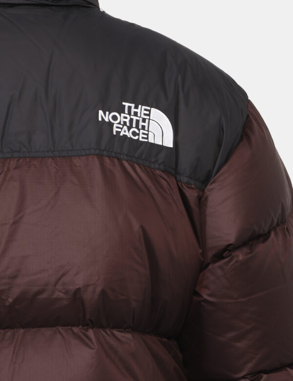 Piumino The North Face Marrone - Piumino bicolor marrone e nero con cappuccio interno. Presenti tasche a taglio trasversale