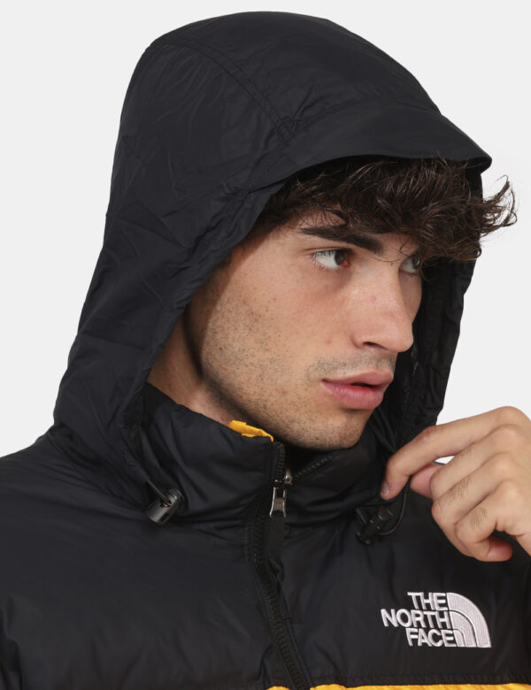 Piumino The North Face Giallo - Piumino bicolor nero e giallo con cappuccio interno. Presenti tasche a taglio trasversale co