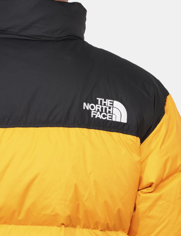 Piumino The North Face Giallo - Piumino bicolor nero e giallo con cappuccio interno. Presenti tasche a taglio trasversale co