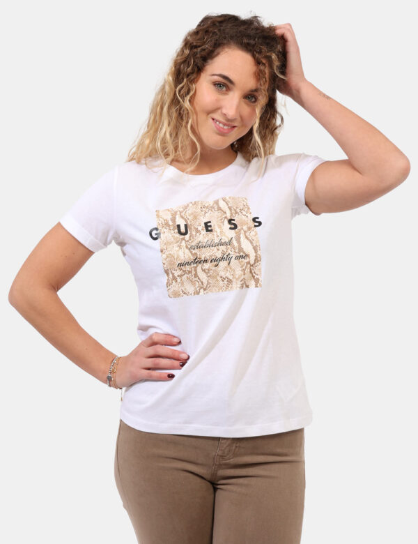 T-shirt Guess Bianco - T-shirt classica su base bianca con stampa logo brand in nero arricchita da glitter dorati. La vestib