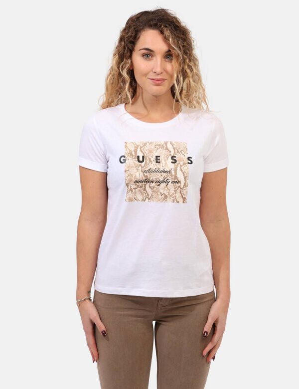 T-shirt Guess Bianco - T-shirt classica su base bianca con stampa logo brand in nero arricchita da glitter dorati. La vestib