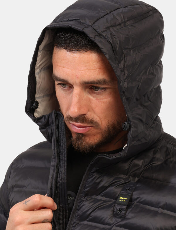 Piumino Blauer Nero - Piumino leggero con cappuccio in total nero. Presenti tasche a taglio trasversale con chiusura a zip,