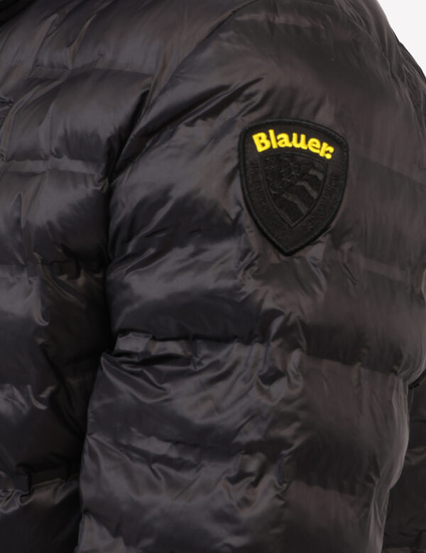 Piumino Blauer Nero - Piumino leggero con cappuccio in total nero. Presenti tasche a taglio trasversale con chiusura a zip,