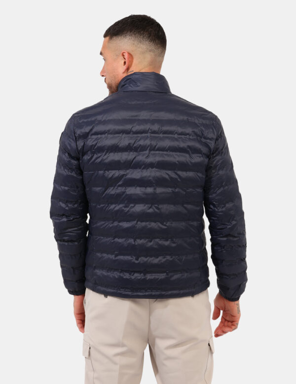 Piumino Blauer Blu - Piumino leggero in total blu scuro. Presenti tasche a taglio trasversale con chiusura a zip, logo sulla