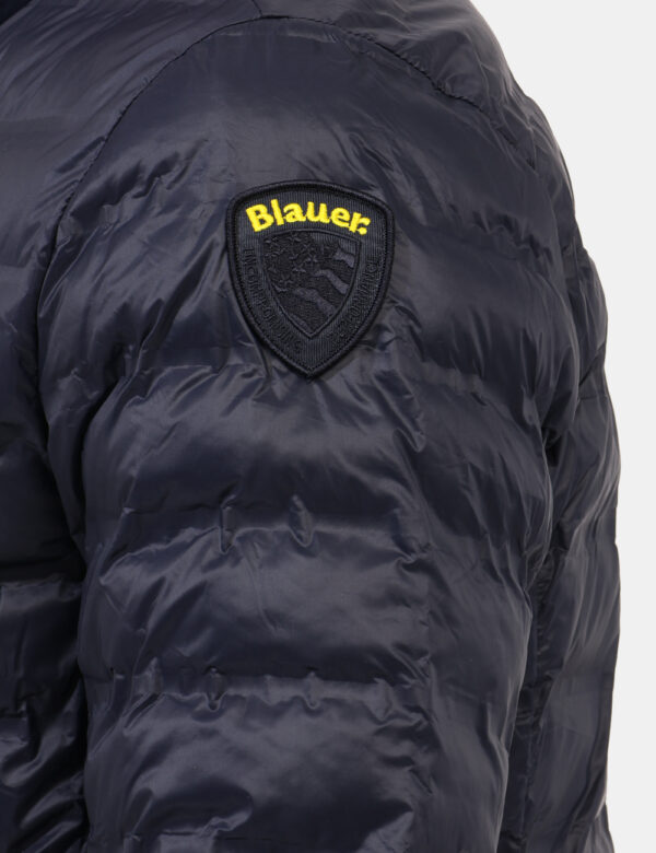 Piumino Blauer Blu - Piumino leggero in total blu scuro. Presenti tasche a taglio trasversale con chiusura a zip, logo sulla