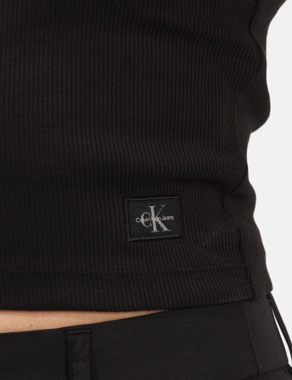 Top Calvin Klein Nero - Top giropetto in total nero con patch logo brand. La vestibilità è morbida e regolare. Il top è adat
