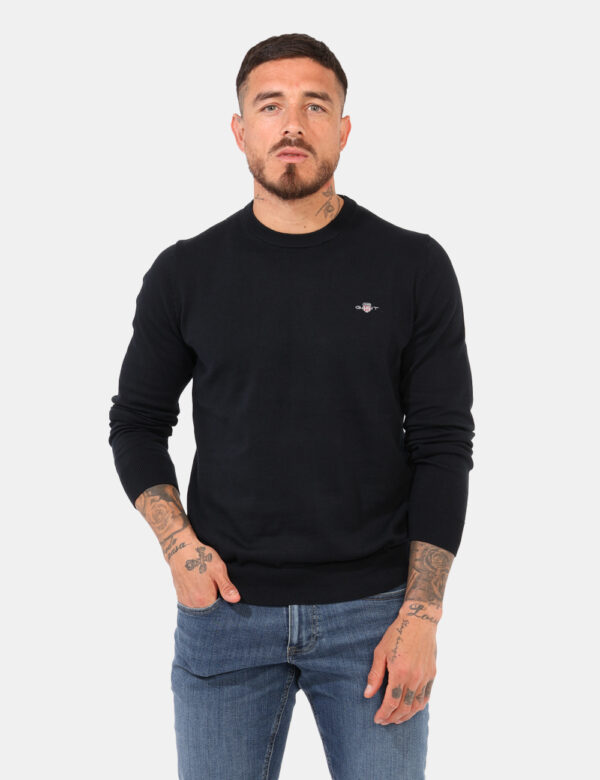 Maglione Gant Blu - Maglione classico in total blu navy con patch logo brand ad altezza cuore. La vestibilità è morbida e ab