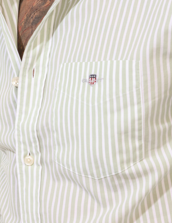 Camicia Gant Verde - Camicia classica su fantasia rigata bianco e verde, con taschino a toppa e patch logo brand. La vestibi