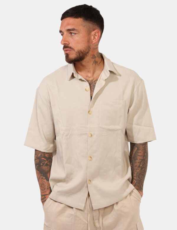 Camicia Goha Beige - Camicia in total beige a maniche corte, con taschino a toppa ad altezza cuore. La vestibilità è morbida