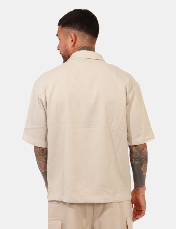 Camicia Goha Beige - Camicia in total beige a maniche corte, con taschino a toppa ad altezza cuore. La vestibilità è morbida