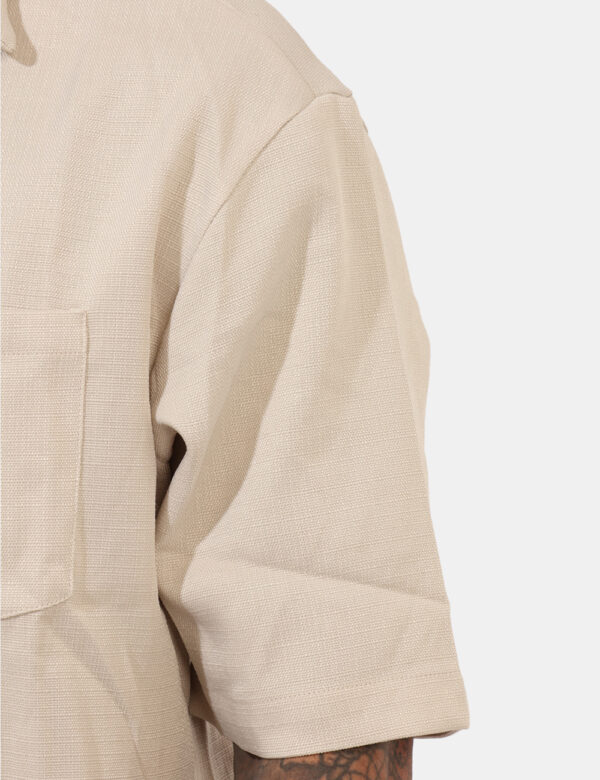Camicia Goha Beige - Camicia in total beige a maniche corte, con taschino a toppa ad altezza cuore. La vestibilità è morbida