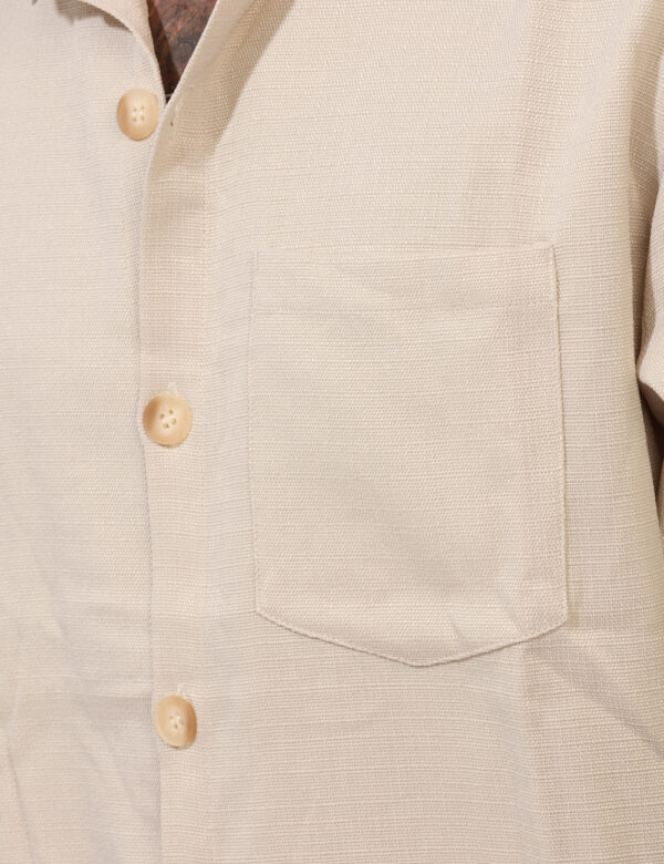 Camicia Goha Beige - Camicia in total beige a maniche corte, con taschino a toppa ad altezza cuore. La vestibilità è morbida