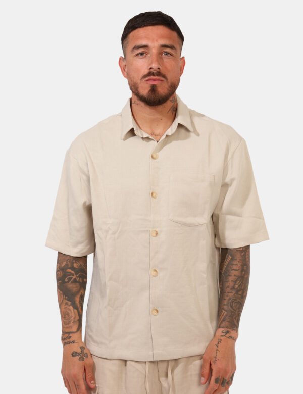 Camicia Goha Beige - Camicia in total beige a maniche corte, con taschino a toppa ad altezza cuore. La vestibilità è morbida