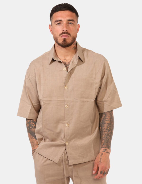 Camicia Goha Beige - Camicia in total beige a maniche corte, con taschino a toppa ad altezza cuore. La vestibilità è morbida