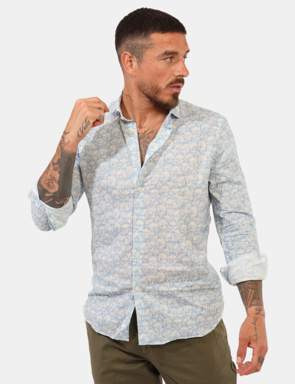 Camicia Goha Azzurro - Camicia su base azzuro chiaro con stampa floreale allover bianca. La vestibilità è morbida e pratica