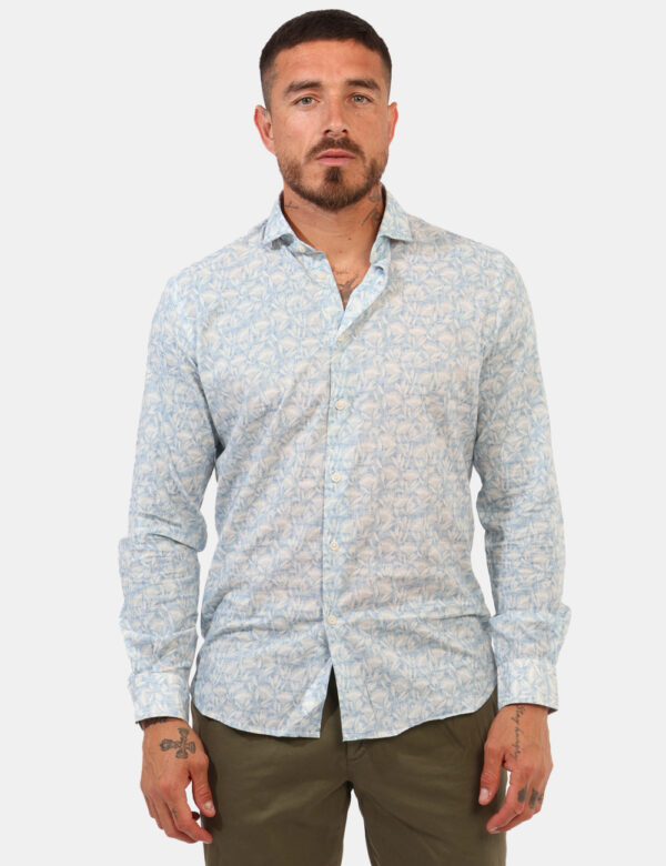 Camicia Goha Azzurro - Camicia su base azzuro chiaro con stampa floreale allover bianca. La vestibilità è morbida e pratica