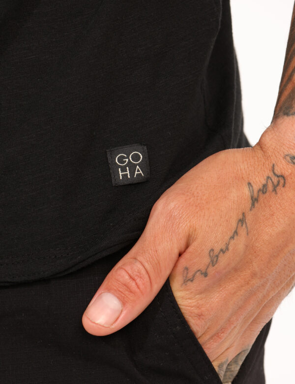 T-shirt Goha Nero - T-shirt classica in total nero con piccolo patch logo brand in tono su tono. La vestibilità è morbida e