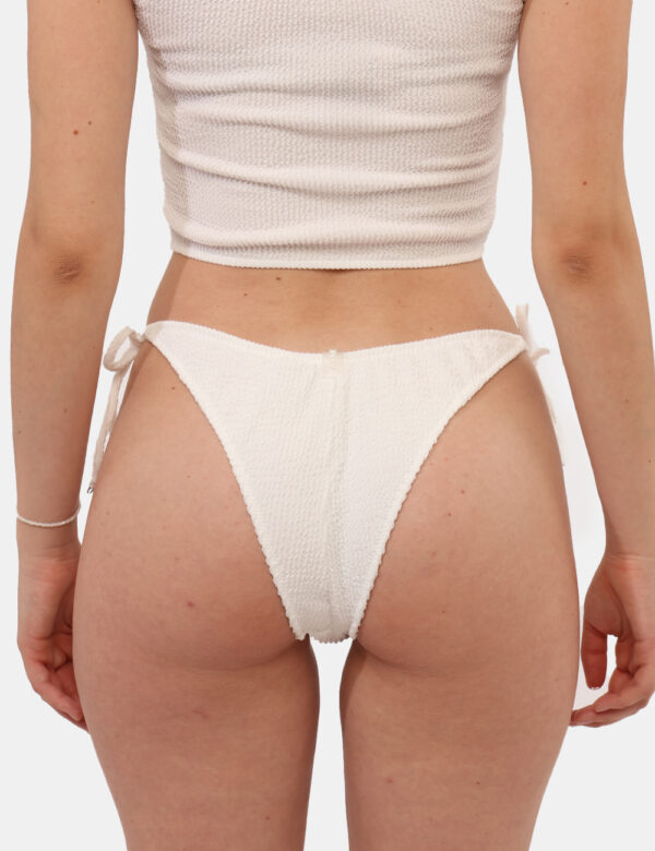 Costume slip F**K Bianco - Costume modello brasiliana in total bianco su tessuto raggrinzito con piccolo patch logo brand. L
