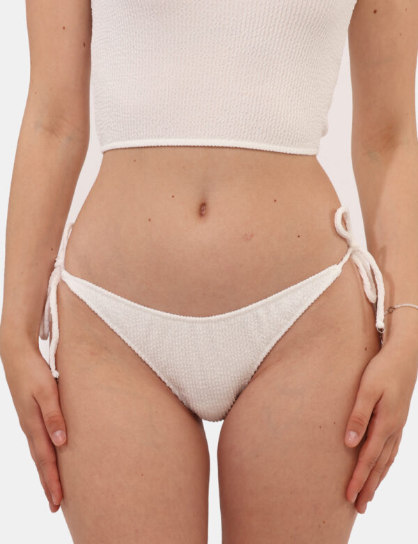 Costume slip F**K Bianco - Costume modello brasiliana in total bianco su tessuto raggrinzito con piccolo patch logo brand. L