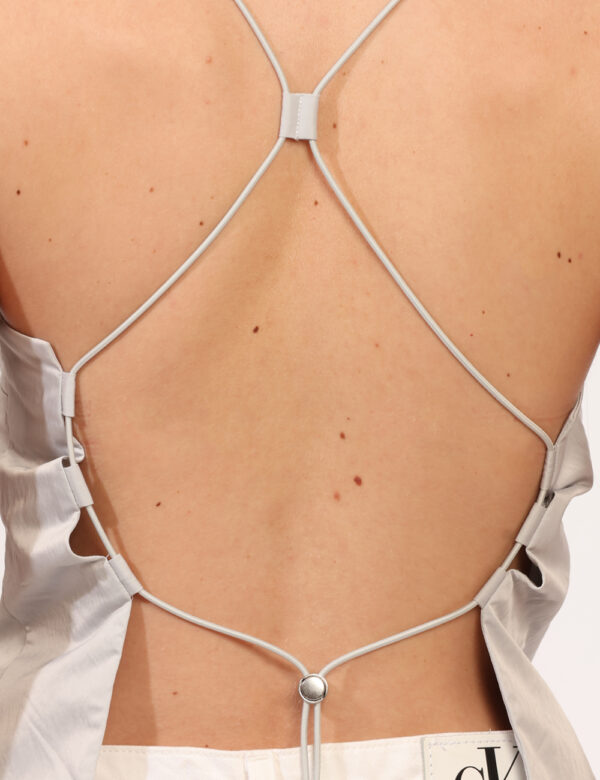 Top Calvin Klein Grigio - Top minimal, in total grigio chiaro, con schiena scoperta e spalline strette. La vestibilità è mor