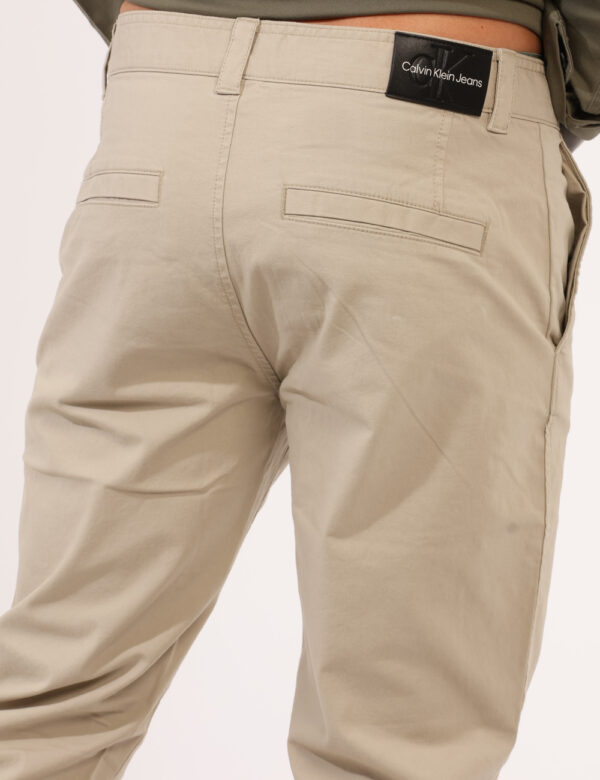 Pantaloni Calvin Klein Beige - Pantaloni in total beige, con tasche a taglio trasversale e fake tasche sul retro. La vestibi