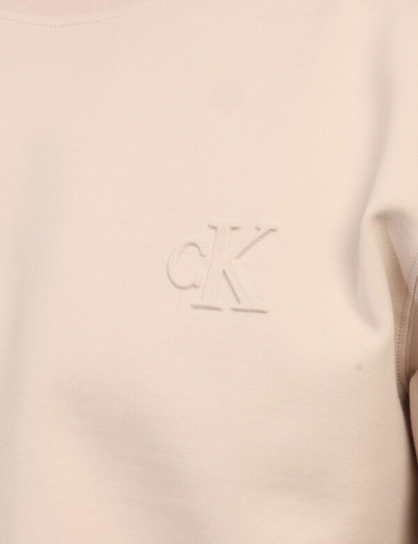 Felpa Calvin Klein Beige - Felpa garzata classica in total beige con logo brand sagomato più polsini ed elastico. La vestibi