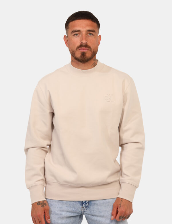Felpa Calvin Klein Beige - Felpa garzata classica in total beige con logo brand sagomato più polsini ed elastico. La vestibi