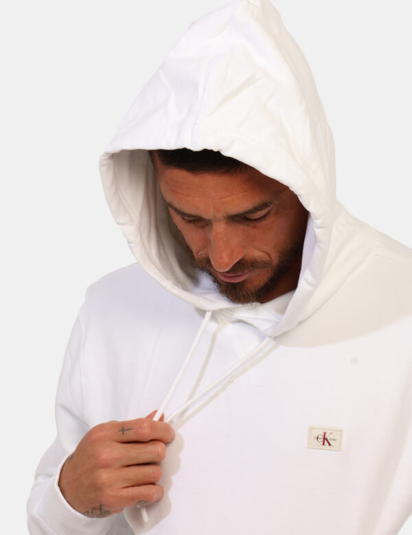 Felpa Calvin Klein Bianco - Felpa garzata con cappuccio in total bianco con patch logo brand. Presente tascone a canguro in
