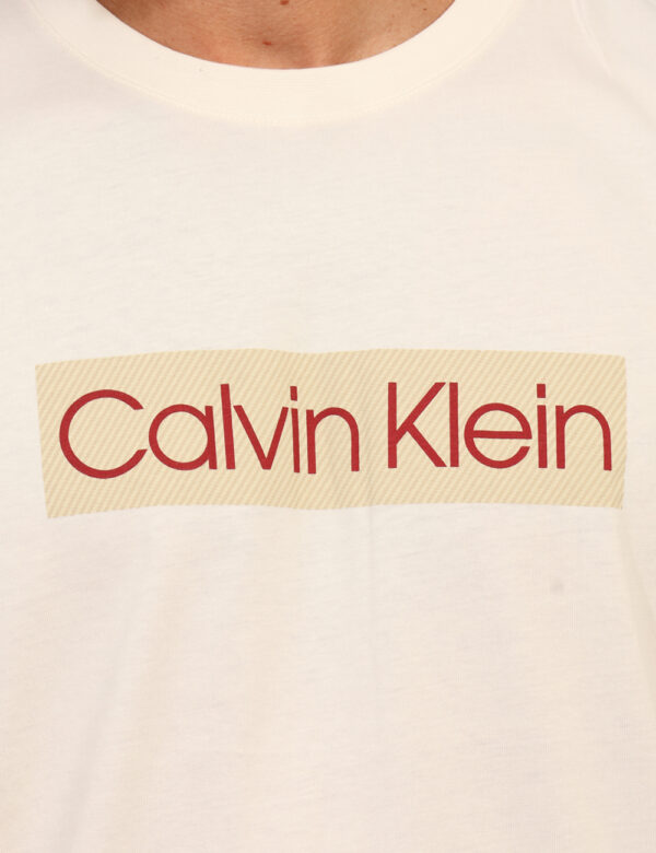 T-shirt Calvin Klein Beige - T-shirt classica su base beige con stampa logo brand coordinata. La vestibilità è morbida e reg