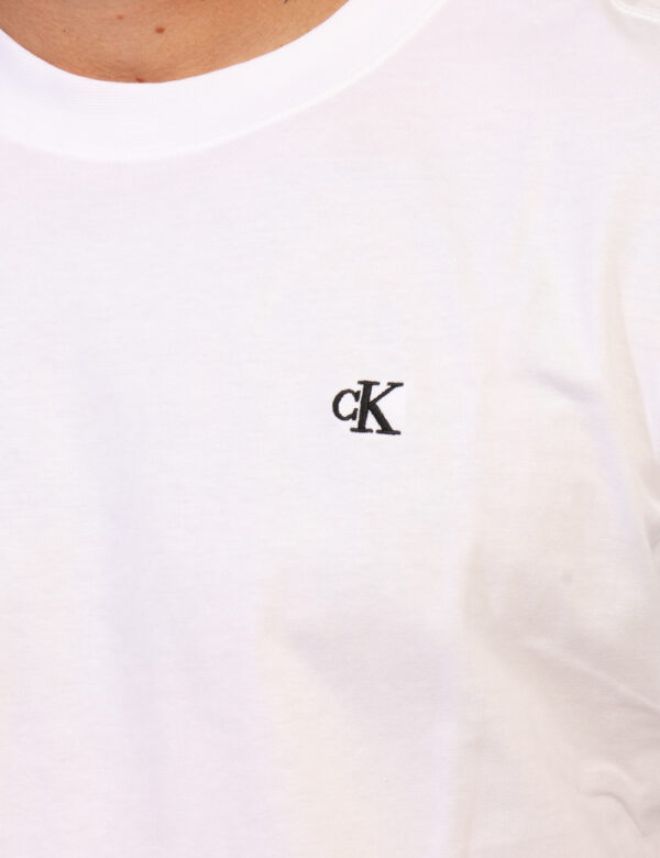 T-shirt Calvin Klein Bianco - T-shirt classica su base bianca con stampa logo brand ricamato nero ad altezza cuore, più stam