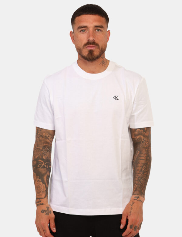 T-shirt Calvin Klein Bianco - T-shirt classica su base bianca con stampa logo brand ricamato nero ad altezza cuore, più stam