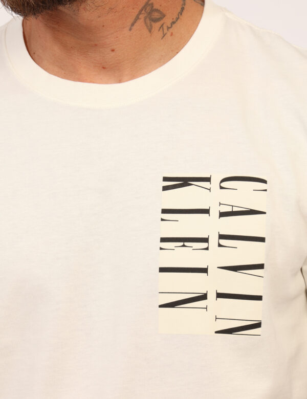 T-shirt Calvin Klein Bianco - T-shirt classica su base bianco con stampa logo brand nera. La vestibilità è morbida e regolar