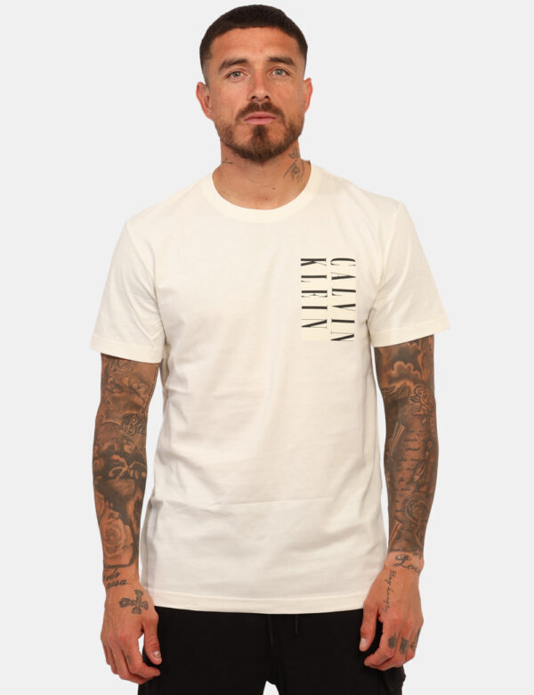 T-shirt Calvin Klein Bianco - T-shirt classica su base bianco con stampa logo brand nera. La vestibilità è morbida e regolar