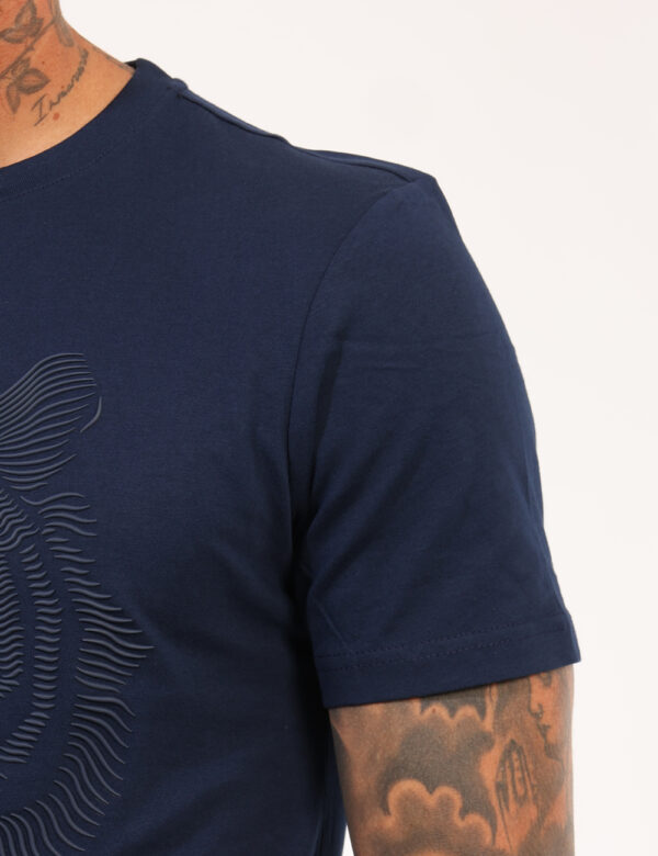 T-shirt Antony Morato Blu - T-shirt su base blu navy con stampa stilizzato leone in rilievo. La vestibilità è morbida e rego
