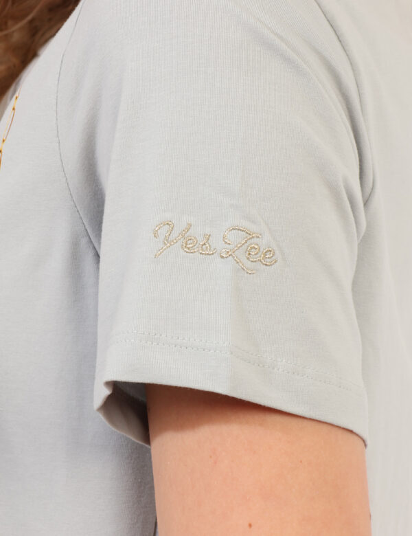 T-shirt Yes Zee Azzurro - T-shirt classica su base azzurro polvere con stampa pendente dal girocollo arricchita da glitter.