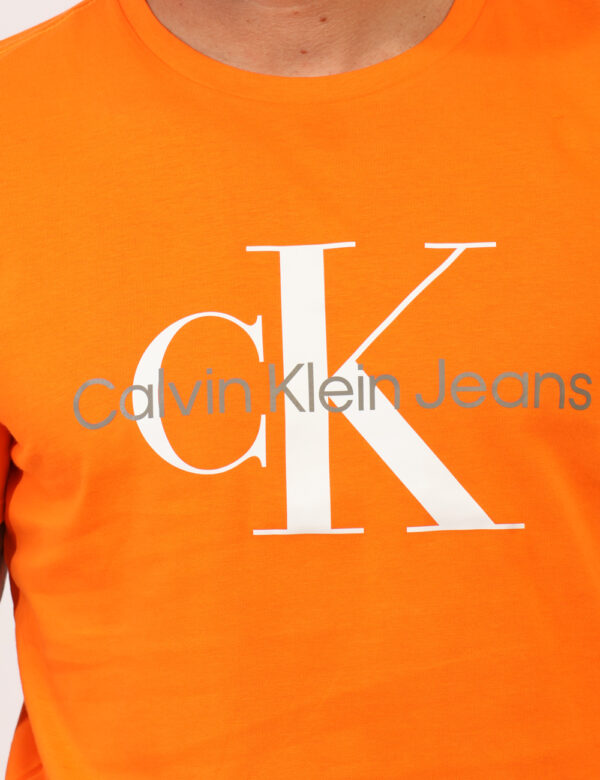 T-shirt Calvin Klein Arancione - T-shirt classica su base arancione con stampa logo brand. La vestibilità è morbida e regola