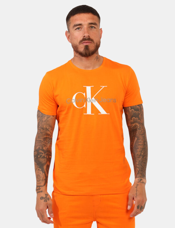 T-shirt Calvin Klein Arancione - T-shirt classica su base arancione con stampa logo brand. La vestibilità è morbida e regola