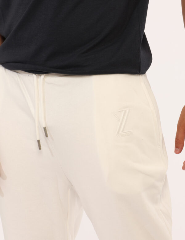 Pantaloni Yes Zee Bianco - Pantaloni simil tuta, in total bianco con tasche a taglio trasversale sul fronte e tasca con zip