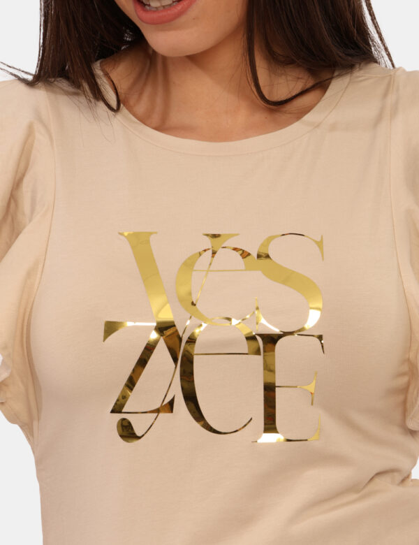 T-shirt Yes Zee Beige - T-shirt su base beige con stampa dorata logo brand, più volant in tinta sulle maniche. La vestibilit