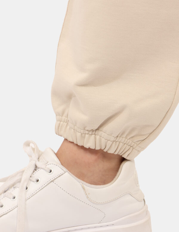 Pantaloni Calvin Klein Beige - Pantaloni tuta in total beige, con logo brand ricamato bianco e tasche a taglio trasversale.