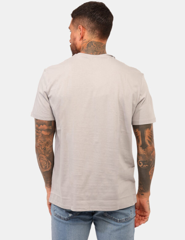 T-shirt Calvin Klein Grigio - T-shirt classica in total grigio chiaro con patch logo brand nero. La vestibilità è morbida e