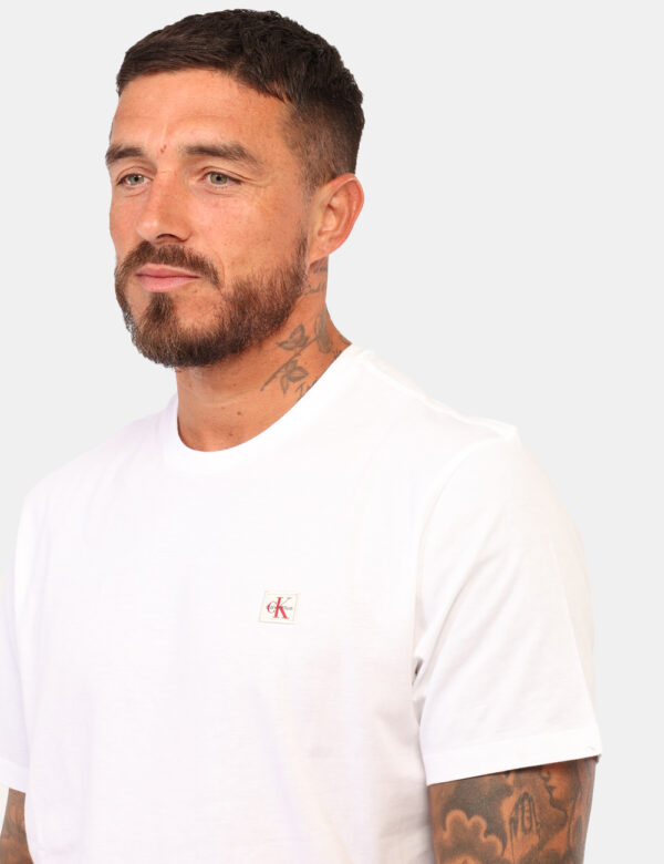 T-shirt Calvin Klein Bianco - T-shirt classica in total bianco con patch logo brand rosso. La vestibilità è morbida e regola